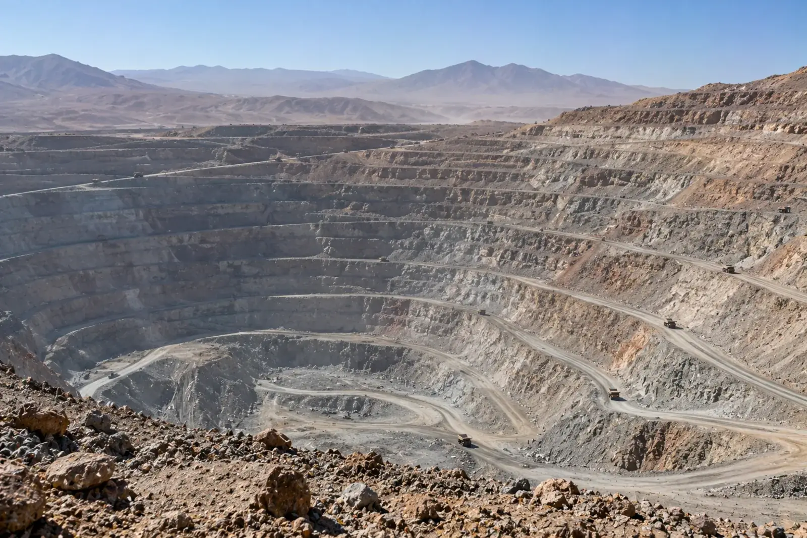 Mina de cobre a cielo abierto vista desde el borde, con bancos escalonados, en el desierto de Atacama.